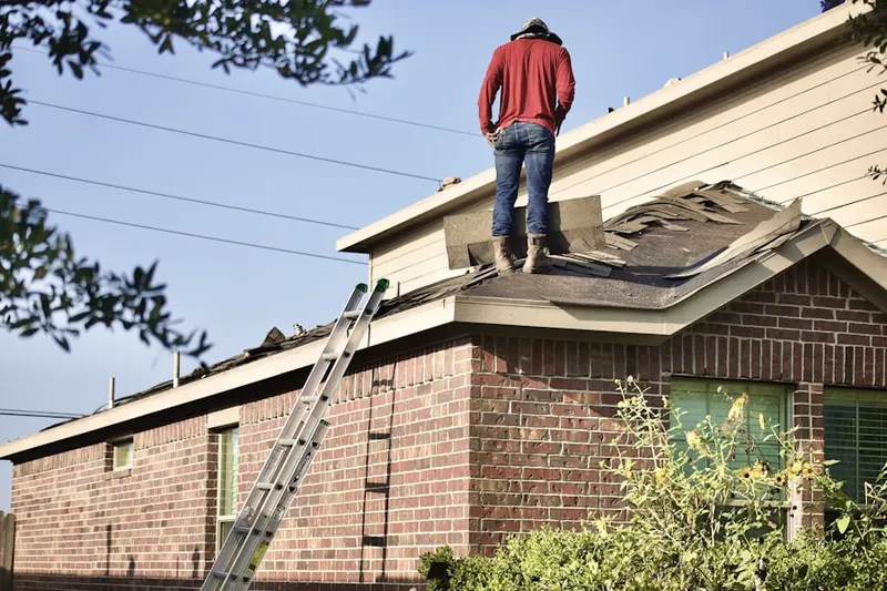 Professional roofer working on a residential roof in West Newbury